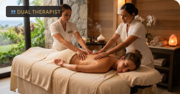 Two therapists performing a synchronized four-hand massage.